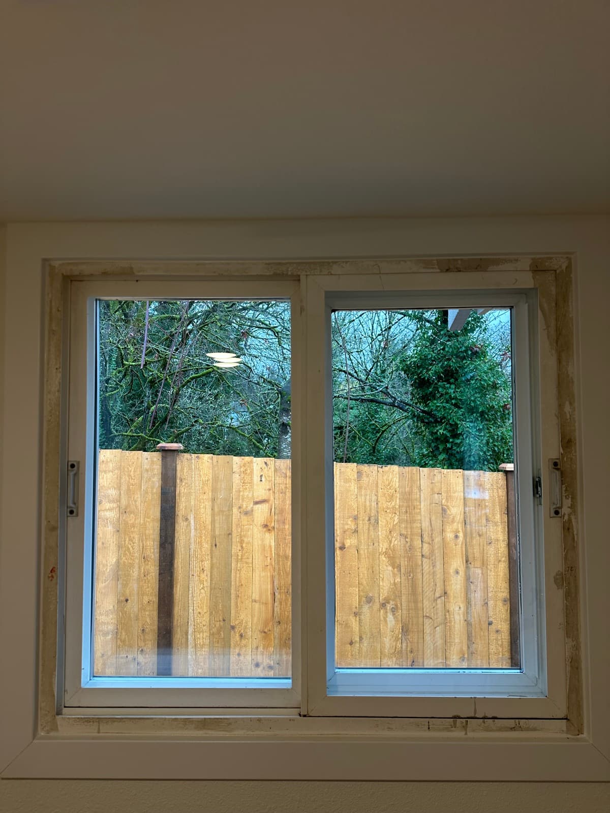 Post-Construction in Renton, WA — Window before cleaning: Boarded up, paint flecks, jobsite dust
